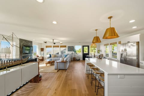 Large open living area with Ocean views, Streaming TV, comfy sectional sofa, gas fireplace, breakfast bar,, and large dining table.