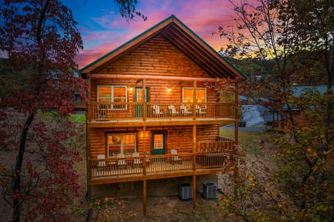 Breathtaking sunset view of this multi-level log cabin with private balconies and warm evening lights. Perfect for romantic escapes, family vacations, and scenic mountain stays.