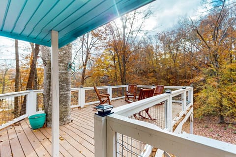 Spacious deck with wooden rocking chairs overlooking the surrounding trees.