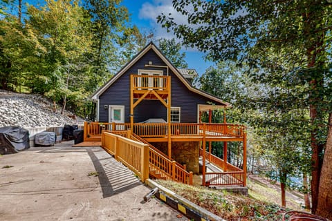 Spacious mountain cabin exterior with multi-level wraparound decks and peaceful wooded surroundings. Perfect for a private getaway, family vacation rental, and relaxing cabin retreat near the lake.
