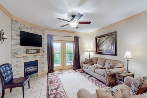 Bright living room with fireplace, smart TV, and balcony access. Perfect for cozy nights after exploring. Ideal for families, couples, and group trips.