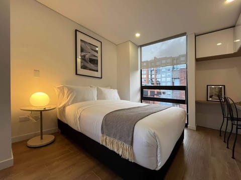Bedroom with warm lighting and large window.