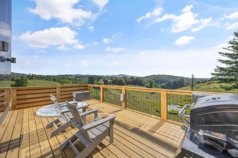 Spacious deck with hot tub, Adirondack seating, grill, and wide-open mountain views