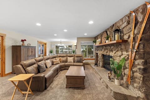 Sink into plush leather seating by your cozy stone fireplace, where rustic charm meets modern comfort in this inviting living space.