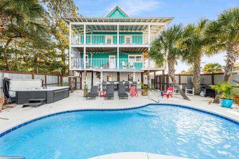 Relax by the pool at this spacious three-story home with multiple balconies and tropical landscaping.