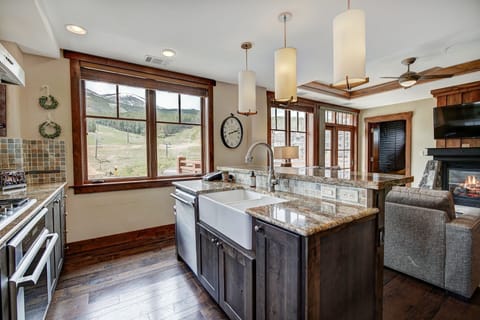 Bright open kitchen and living space with a breakfast island and scenic views — perfect for entertaining or casual dining.