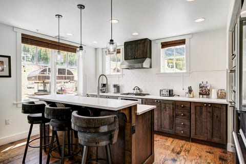 Modern kitchen nook with sleek countertops, dark wood accents, and bar seating for casual dining or morning coffee.