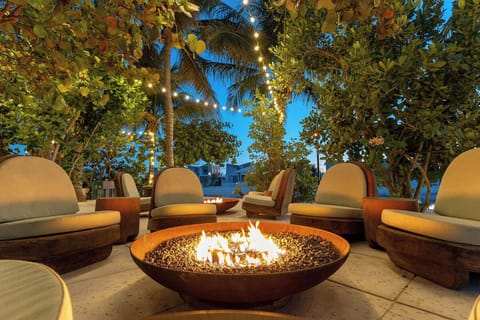 Gather under palms as tiki lights glow into evening.