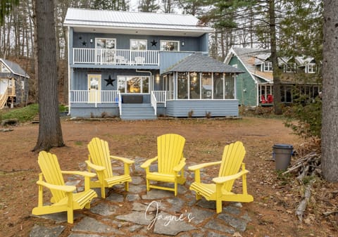 Cozy lakeside fire pit with vibrant Adirondack chairs and spacious porch