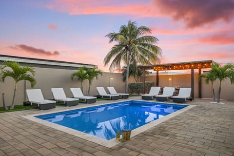 Palm Beach retreat with private pool, lounge beds, and cozy pergola seating