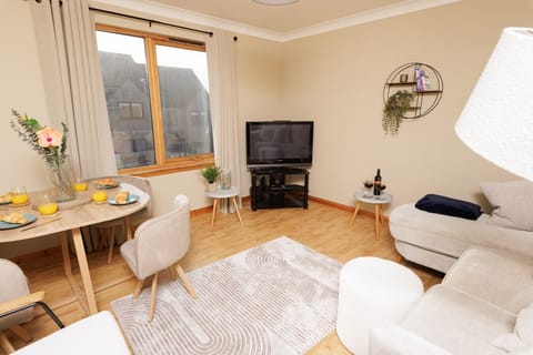 Bright living and dining area with TV