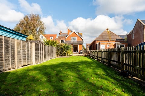 Long private garden with seating area and stream at the bottom