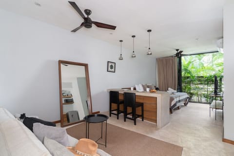 Bright modern studio with lush greenery and a cozy dining bar.