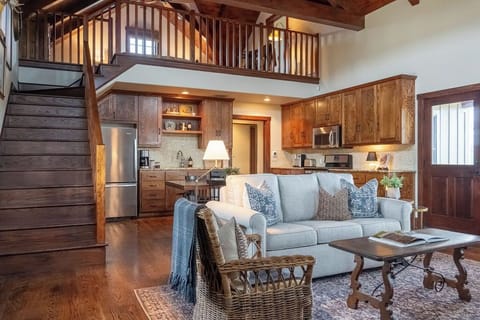 The living room, with soaring wood planked ceilings and a limestone fireplace.
