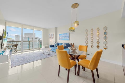 Bright, open-concept living and dining space with floor-to-ceiling windows.