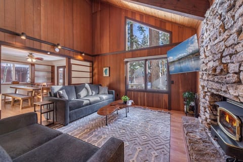 Cozy up in your warm living space with crackling fireplace, comfortable seating, and stunning natural views through floor-to-ceiling windows.