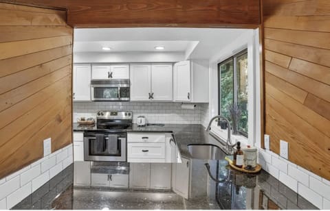 Well-stocked kitchen features granite countertops and quality appliances