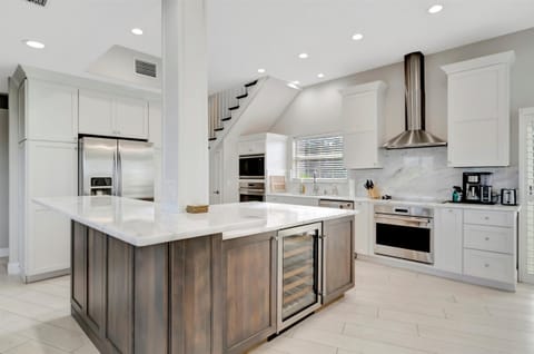 Open layout kitchen with stainless steel appliances, wine fridge, and all the supplies!