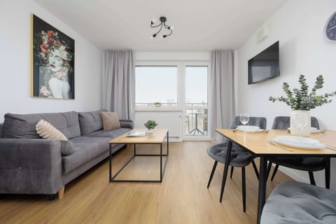 The soft sofa with light cushions creates a pleasant place to unwind, while the large window brings in daylight that instantly lifts the guest experience.