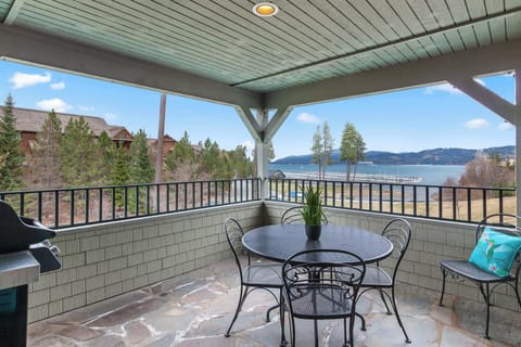Covered balcony with flagstone floor, iron bistro set, gas grill, and sweeping lake-and-mountain views