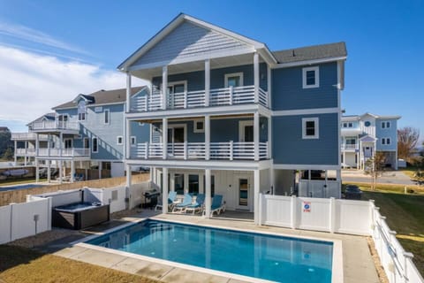 Soundside Serenity at Cruz Bay, Corolla — featuring a private pool, hot tub, infinity game table, and pier access. Managed by Rather Be Properties.