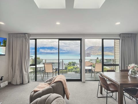 Bright open-plan living and dining area with lake and mountain views