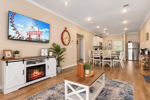 Open living area with large TV and cozy fire feature.