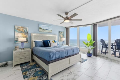 Wake up to breathtaking ocean views in this spacious king bedroom featuring floor-to-ceiling windows, direct private balcony access, and coastal décor. A relaxing beachfront retreat for your perfect beach stay.