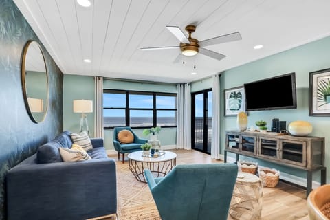 Unwind in a bright coastal living room with ocean views, stylish seating, and balcony access. This beach stay retreat offers modern comfort, natural light, and a relaxing space to enjoy your seaside vacation.