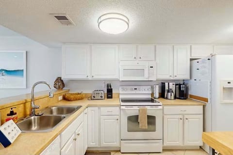 This fully equipped coastal kitchen is perfect for a relaxing beach stay, featuring modern appliances, ample counter space, and bright cabinetry—ideal for preparing meals after a day at the beach or enjoying a casual seaside breakfast.
