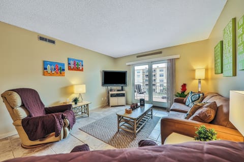 Relax during your beach stay in this inviting living room featuring comfortable seating, coastal décor, and sliding doors to the balcony. Perfect for unwinding after a day at the beach or enjoying a cozy night in.