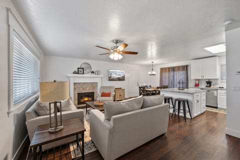 A large comfortable primary living room with plenty of plush seating, fireplace, and beautifully decorated