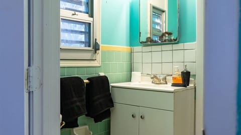 Bathroom vanity with towels, mirror, and shower access