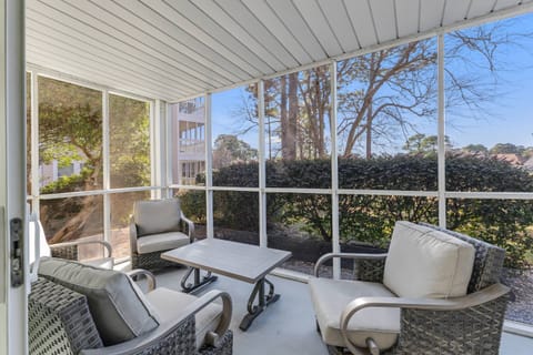 Relax on the screened porch with cushioned seating, peaceful garden views, and fresh air, perfect for morning coffee or evening drinks.