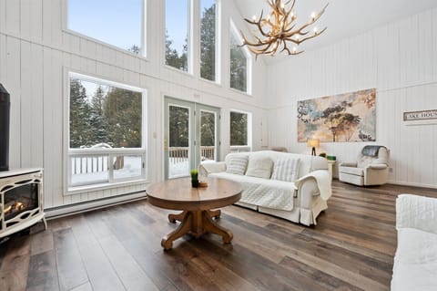 Inviting living area with plush seating, statement chandelier, and access to outdoor deck