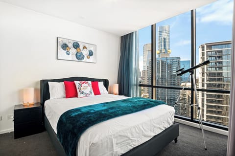 Bright queen room with luxe bed and panoramic views of Melbourne’s skyline