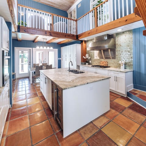 Kitchen Open to Family Room above with tropical Mexican-tile floor