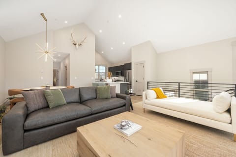 Relax in this stunning open-concept living space where modern elegance meets cozy comfort, featuring soaring ceilings and stylish furnishings.