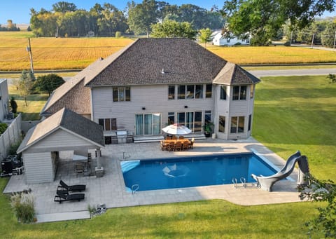 Heated saltwater pool with slide, plus an outdoor kitchen and covered seating.