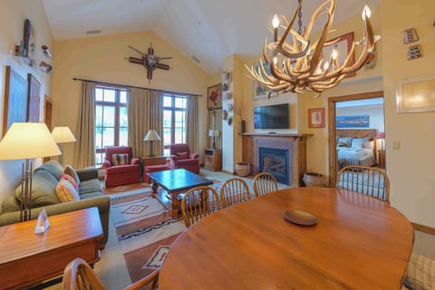 The sunlit living area features a blend of plush seating and rustic mountain-inspired décor, creating a cozy yet elegant atmosphere.