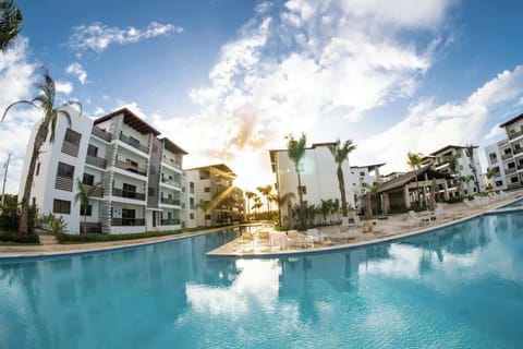 - Resort style pool view with palm trees and modern buildings ideal for family stays
- Large shared swimming pool with sun loungers and calm evening reflections
- Secure gated complex close to beach restaurants shops and local attractions

