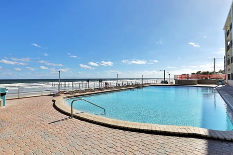 Large oceanfront pool with expansive deck and sweeping beach views. Ideal for a relaxing beach stay, offering plenty of space to swim, lounge, and enjoy ocean breezes just steps from the sand.