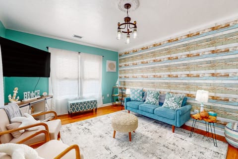 Relax in this inviting beach stay living room featuring coastal décor, comfy seating, a flat-screen TV, and warm wood floors. Perfect for unwinding after a day at the beach and enjoying laid-back seaside living.