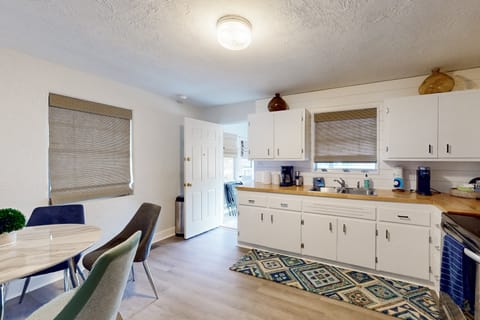 Open, beach-inspired kitchen and dining area with modern conveniences and easy outdoor access—perfect for shared meals, morning coffee, and relaxed living during your enjoyable beach stay.