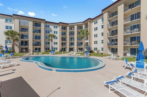 Enhance your beach stay with access to this spacious resort-style pool surrounded by lounge chairs and palm trees. A perfect place to relax, soak up the sun, and enjoy coastal living just steps from your condo.