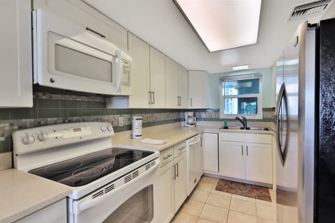 This clean, fully equipped beach stay kitchen features modern appliances, ample counter space, and a bright coastal feel—perfect for preparing meals and snacks before or after a relaxing day at the beach.