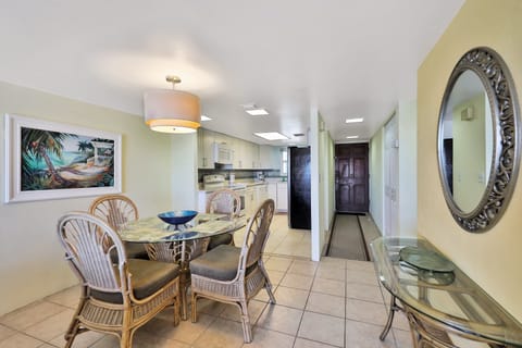 This inviting beach stay dining area flows into a bright kitchen and welcoming entryway. Coastal décor and an open layout create a relaxed space to gather, dine, and unwind after a fun day at the beach.