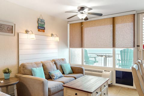 Bright, coastal living room with ocean views, comfy seating, and beach-inspired décor. Step onto the balcony, relax under the ceiling fan, and enjoy an inviting beach stay just steps from the shore.