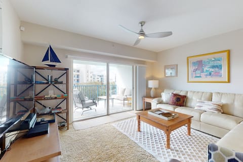 Relax in this sun-filled coastal living room featuring comfortable seating, beach-inspired décor, and sliding doors to a private balcony. Perfect for a beach stay, just moments from sand, sea breezes, and coastal relaxation.