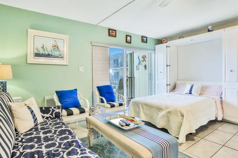 Unwind in this inviting coastal studio featuring a comfortable bed, seating area, and access to a private balcony. Soft beach-inspired décor creates the perfect setting for a peaceful and memorable beach stay.